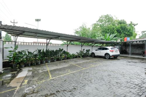 a white car parked in a parking lot at Urbanview Hotel DHelomi Homestay near UPN Veteran in Kalasan