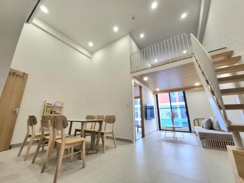 un soggiorno con tavolo, sedie e scala di My SunArt a Quang Ãm