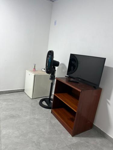 ein Zimmer mit einem Fernseher und einer Kamera auf einem Schreibtisch in der Unterkunft Suíte Brisa Mar Saquarema in Saquarema