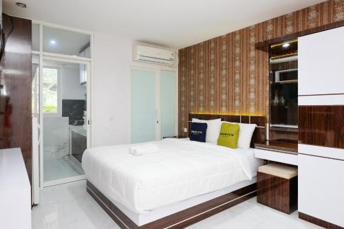 a bedroom with a white bed and a shower at Urbanview Hotel DHelomi Homestay near UPN Veteran in Kalasan