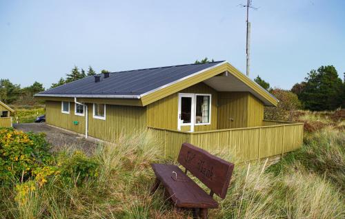 a small yellow house with a bench in front of it at Holiday Home Mågevej Rømø Iv in Rømø
