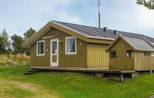 a small wooden house on a grass field at Holiday Home Mågevej Rømø Iv in Rømø