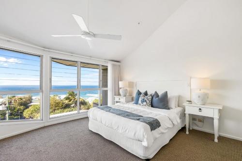 ein weißes Schlafzimmer mit einem Bett und einem großen Fenster in der Unterkunft 8 Andari Sunshine Luxury 1min to Beach in Sunshine Beach