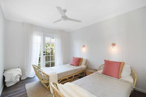 una habitación con dos camas y una ventana en The River Shack Vintage Luxe Right Beside River, en Noosaville
