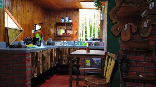 a kitchen with a sink and a counter with a table at Tesorito House en las Montañas del Quindío in Filandia