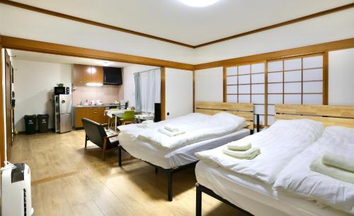 a hotel room with two beds and a kitchen at Dream Tree 札幌市电步行0分钟 超市步行1分钟 in Sapporo