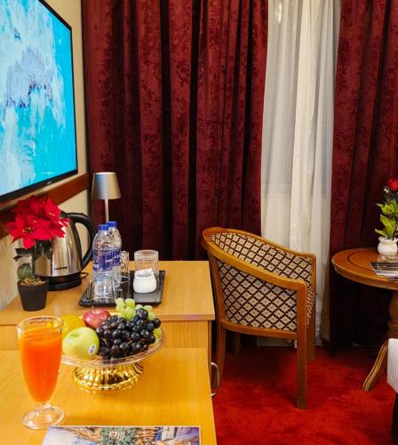 a living room with a table with a plate of fruit on it at Golden California Hotel in Dubai