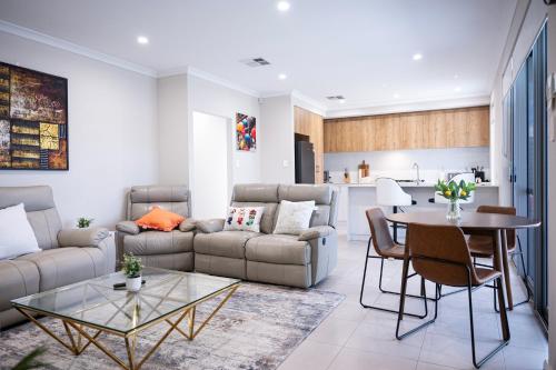 a living room with a couch and a table at New beautiful Cozy front house in Perth