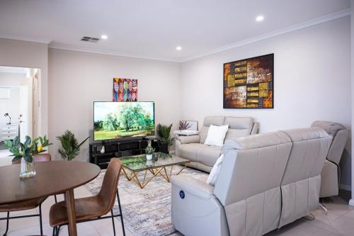 a living room with a couch and a tv at New beautiful Cozy front house in Perth