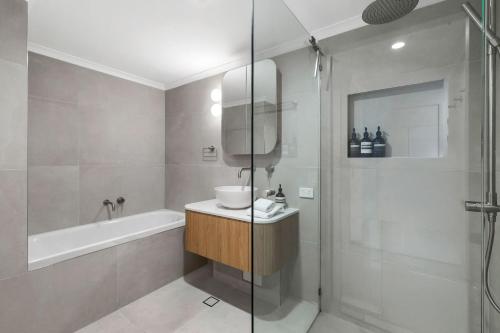 a bathroom with a shower and a sink and a tub at Unit 3 21 Park Generous and Comfortable Beachside Abode in Sunshine Beach