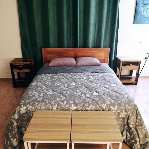 a bedroom with a bed with a green curtain at Casa Ix Milagros in Huay Pix