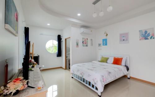 Postel nebo postele na pokoji v ubytování Baan Iris Salaya