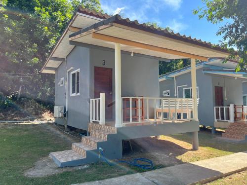 ein kleines Haus mit einer großen Veranda in der Unterkunft Ban Supattra in Ban Khlong Mat