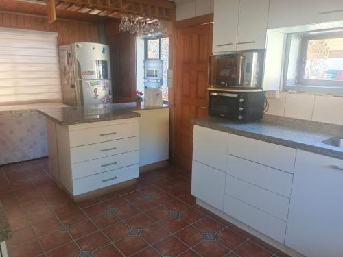 une cuisine avec des armoires blanches et un comptoir dans l'établissement Casa en el quisco 10 personas con piscina, à El Quisco