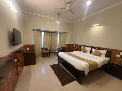 een slaapkamer met een bed en een flatscreen-tv bij IVY The Boutique Hotel By Backpacker Stop in Nainital