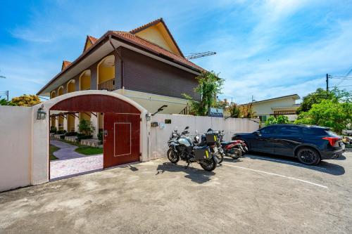 a couple of motorcycles parked in front of a house at Chernin Apartment Suites, Rawai in Ban Saiyuan (1)