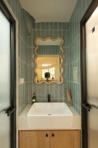 ein Badezimmer mit einem weißen Waschbecken und einem Spiegel in der Unterkunft Lebatriu in Hanoi