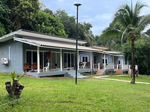 una casa blu con una palma nel cortile di Ban Supattra a Ban Khlong Mat