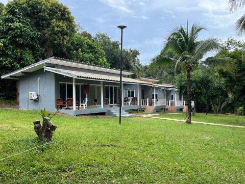 Ein Haus in einem Garten mit einem Hydranten im Gras in der Unterkunft Ban Supattra in Ban Khlong Mat