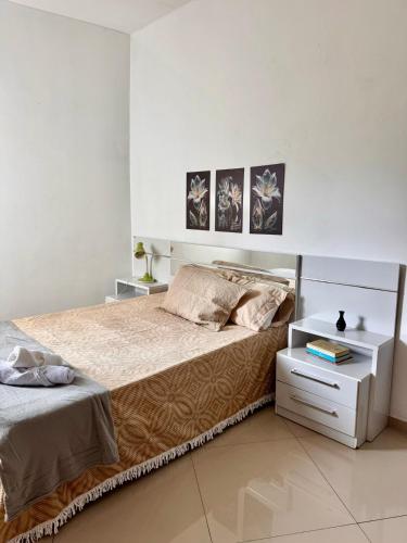 维多利亚-达孔基斯塔Aconchego Smart - Perto de tudo!的一间卧室配有一张大床和一个床头柜