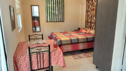 een kamer met twee bedden en twee tafels erin bij La Casita in Gamboa