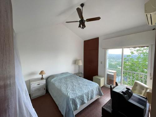una camera da letto con un letto e un ventilatore a soffitto di Casa de Alvita a Villa Carlos Paz