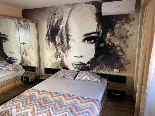 een slaapkamer met een schilderij van een vrouw aan de muur bij Valivillas Studio in Boekarest
