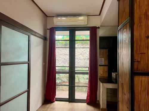 a room with a large window with red curtains at Laan Mai Fai Chang Resort in Chiang Mai