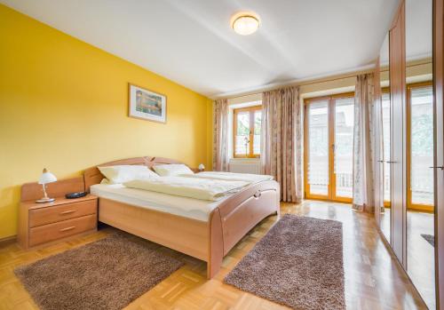 a bedroom with a bed and a yellow wall at Ferienwohnung Lex in Bad Griesbach