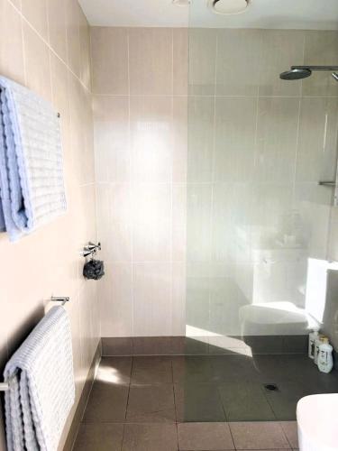 a bathroom with a shower with a toilet and a sink at PIER POINT 3 Bedroom Deluxe Apartment located on The Geelong Waterfront - 106 in Geelong
