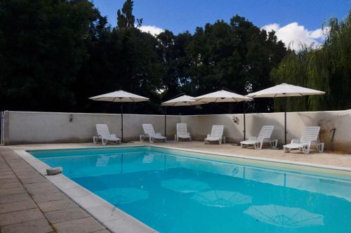 une piscine avec chaises et parasols dans l'établissement Chez Fins Bois, à Néré