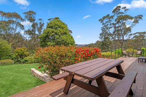 a wooden picnic table sitting on a wooden deck at Banksia Tops in Leura