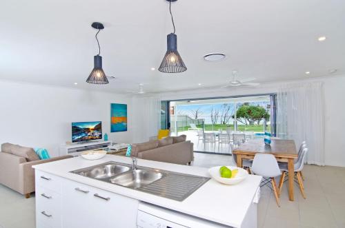 a kitchen and living room with a sink and a table at Sentosa on Tugun in Gold Coast