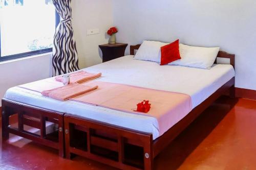 a bedroom with a large bed with red pillows at sea scape homestay in Mararikulam