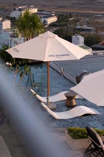 an umbrella sitting on top of a swimming pool at December Hotel in Nha Trang