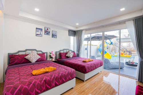 a bedroom with two beds and an umbrella at Sea Fan Cha-am Pool Villa in Ban Bo Prakhon
