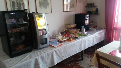 a table in a kitchen with a counter with a refrigerator at B&B L'Isola in Porto Cesareo