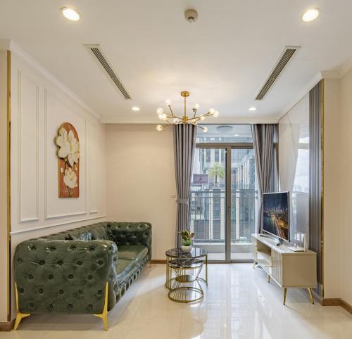 a living room with a green couch and a television at Luminous Landmark Apartment in Ho Chi Minh City