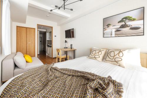 a bedroom with a bed and a couch at Dash Living Shinjuku in Tokyo