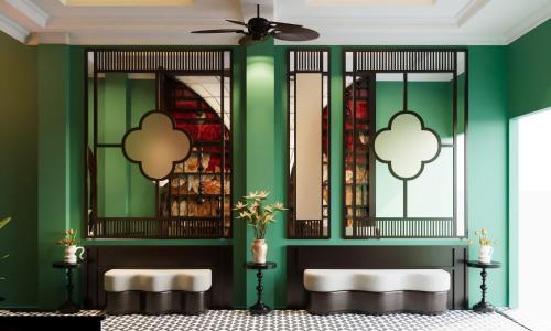 a green room with two benches and a ceiling fan at Hanoi Ancient Paradise Hotel in Hanoi