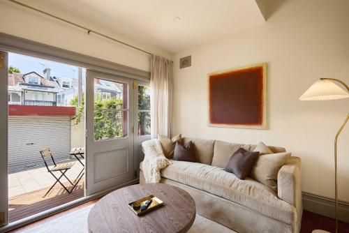 a living room with a couch and a table at Grand 4BR Paddington Terrace - Free parking in Sydney