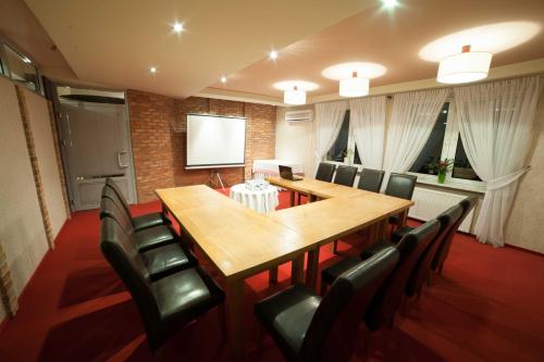 a conference room with a long wooden table and black chairs at Sosnowe Zacisze in Białystok