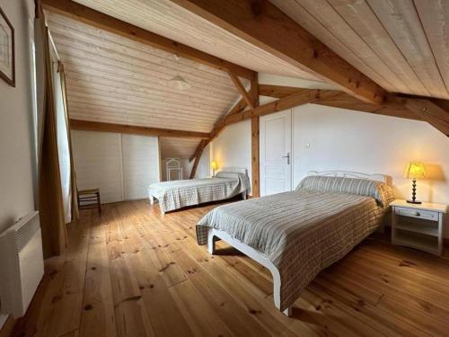 a bedroom with two beds and a wooden ceiling at Gite de lescurade in Escource