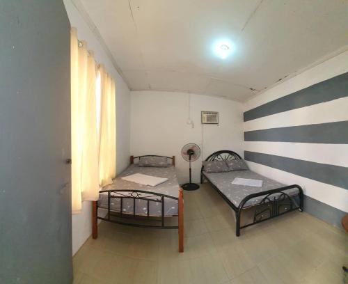a room with two beds and a wall with stripes at Kantil Dive Resort in Batangas City