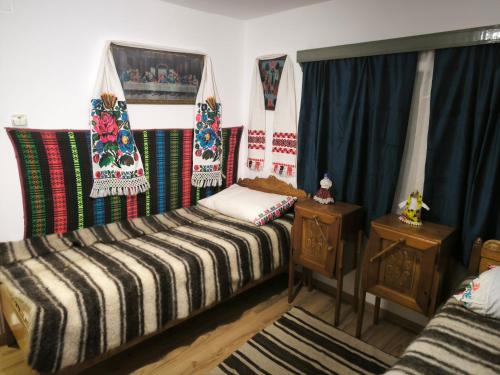 una stanza con un letto, due tavoli e delle tende di Casa Lăpușană a Lăpuş
