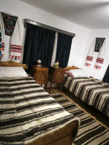 two beds in a room with a large window at Casa Lăpușană in Lăpuş