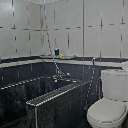 a bathroom with a toilet and a bath tub at Coco Haven Mauritius in Belle Mare
