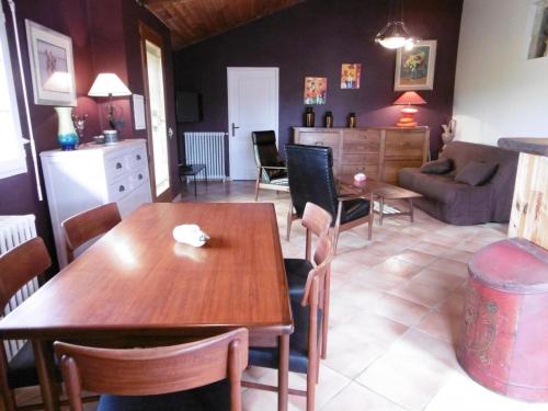 una cucina e un soggiorno con tavolo e sedie in legno di Le coursin a Saubrigues