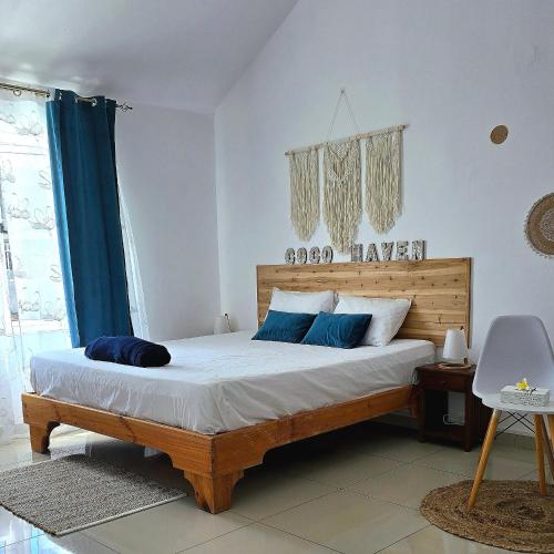 a bedroom with a large bed with blue pillows at Coco Haven Mauritius in Belle Mare