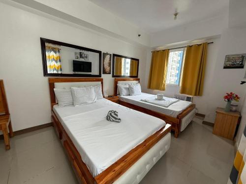 1 Schlafzimmer mit 2 Betten und einem TV in der Unterkunft Sea Residences Wonders in Manila